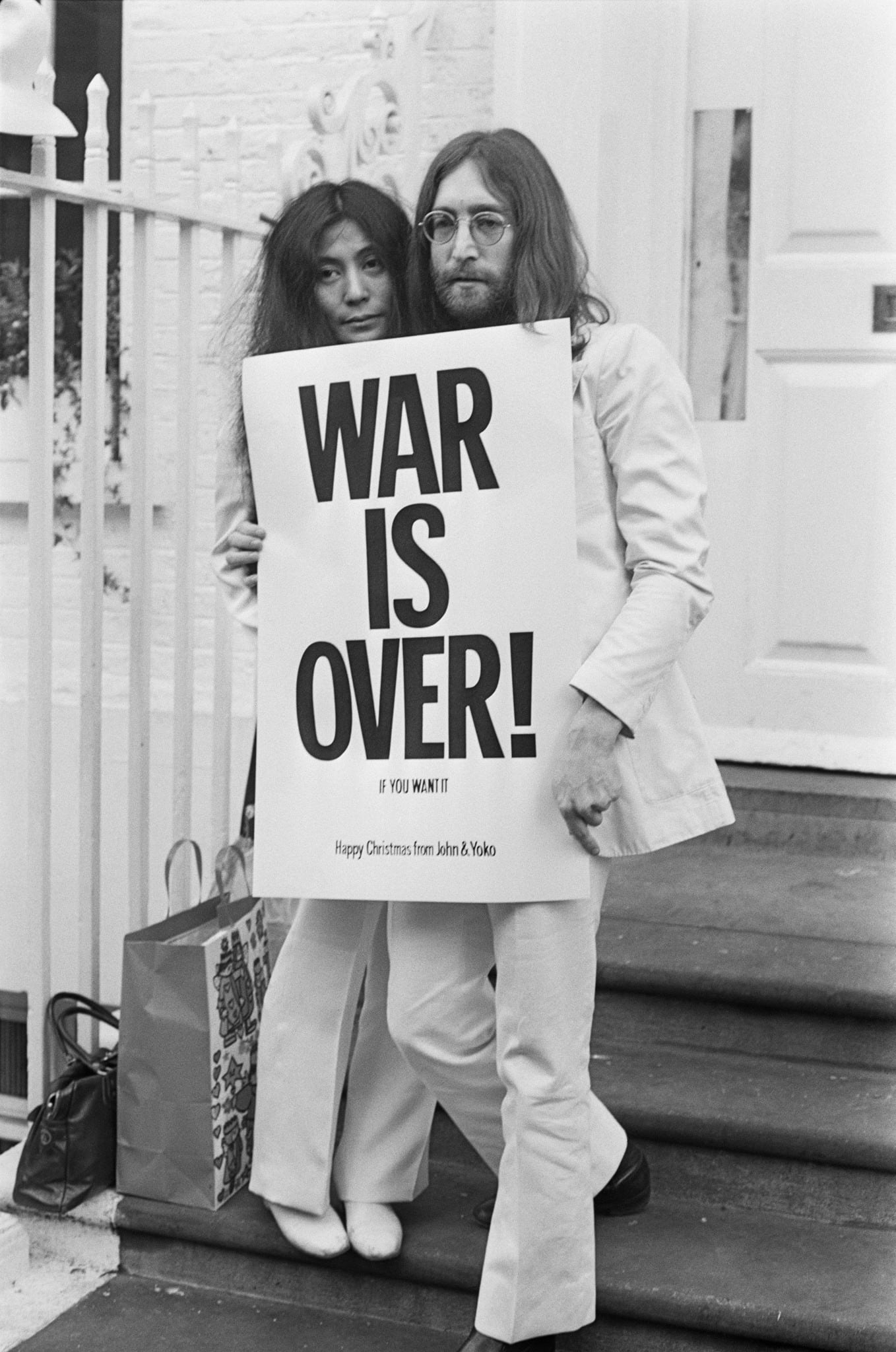 John Lennon and Yoko Ono holding a poster that reads, "War is Over! If you want it."